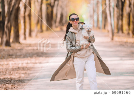 Young stylish woman walking with white dog 69691566