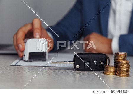 Man is stamping contract for purchase car. Concept of purchase and insurance with car 69691882