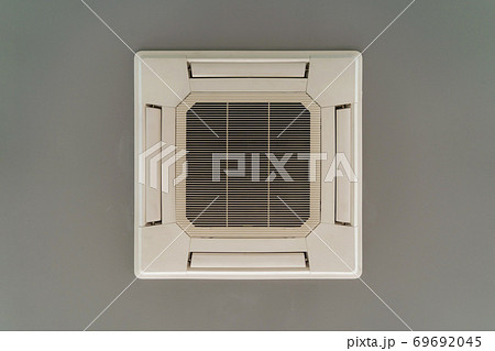 Modern white ceiling mounted cassette type air conditioner in office building system work. Ventilation compressor. Modern white ceiling mounted cassette type air conditioner in office building system work. Ventilation compressor. 69692045