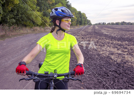 Beautiful girl cyclist with a bicycle on the nature.  69694734