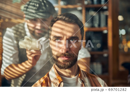 Grey-eyed hipster with a beard waiting to get a haircut 69701282
