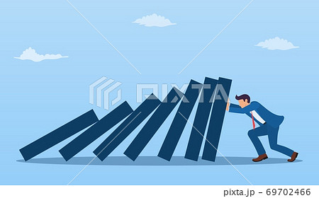 Businessman pushing against falling deck of domino Businessman pushing against falling deck of domino 69702466