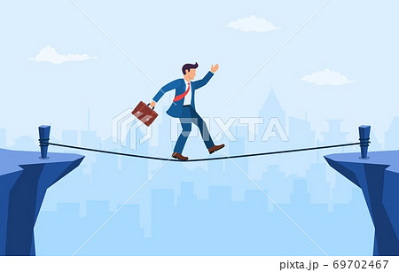 Businessman is walking a tightrope across the gap between the rocks. Businessman is walking a tightrope across the gap between the rocks. 69702467