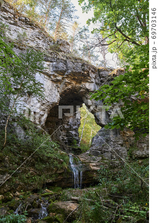 view of a small mountain river waterfall among large cobblestones from a cliff. view of a small mountain river waterfall among large cobblestones from a cliff. 69703146