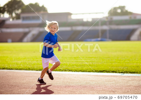 Child running in stadium. Kids run. Healthy sport. 69705470