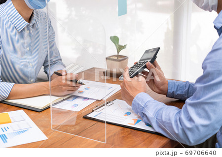 business team brainstorm they are working hard by looking through the plastic protective wall, concept of social distancing to prevent the spread of coronaviru COVID-19. business team brainstorm they are working hard by looking through the plastic protective wall, concept of social distancing to prevent the spread of coronaviru COVID-19. 69706640
