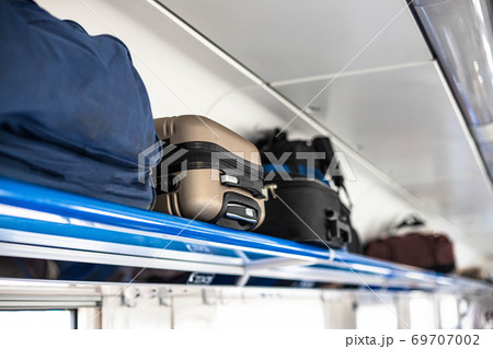 Holiday vacation, tourism, travel, modern train interior, of railway transportation concept. Luggage on shelf railway train. 69707002