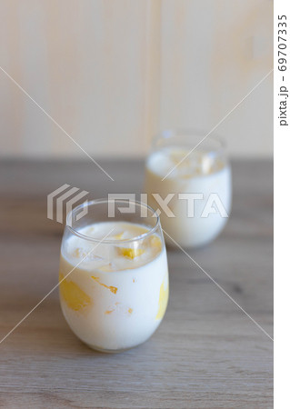 Delicious sweet cream ice cream dessert with melon in glasses on wooden background. Vertical photo 69707335