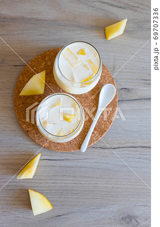 Delicious sweet cream ice cream dessert with melon in glasses on wooden background 69707336