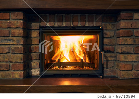 fireplace and fire close view as object or background, brick wall 69710994