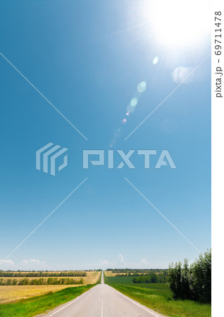 Empty country road on a summer day with green plantings of forest and greenery on the sides 69711478