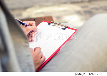 Female hand writing on a blank planner Female hand writing on a blank planner 69712036