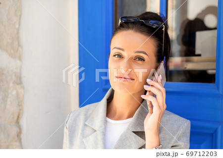 Business woman talks on cell phone Business woman talks on cell phone 69712203