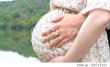 マタニティのお腹を撫でている両親 マタニティのお腹を撫でている両親 69712421