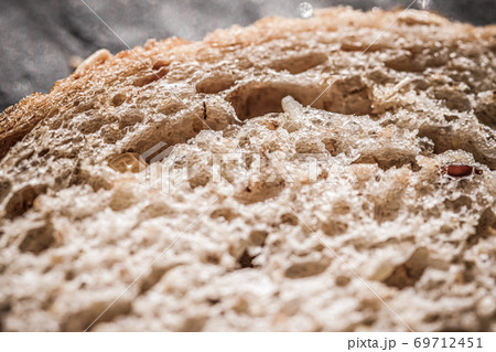 Fresh whole grain seeded bread, organic wheat flour, closeup slice texture as background for food blog or cook book recipe 69712451