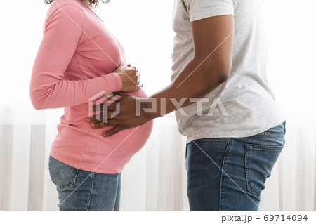 Closeup of african american pregnant couple embracing at home 69714094