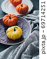 Festive composition. Miniature decorative pumpkins on a stone table top. 69714251