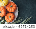 Festive composition. Miniature decorative pumpkins on a stone table top. 69714253