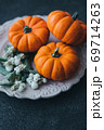 Festive composition. Miniature decorative pumpkins on a stone table top. 69714263