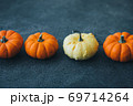 Festive composition. Miniature decorative pumpkins on a stone table top. 69714264