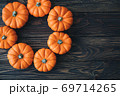 Autumn composition of miniature decorative pumpkins on a wooden table. 69714265