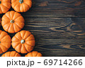 Autumn composition of miniature decorative pumpkins on a wooden table. 69714266