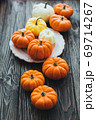 Autumn composition of miniature decorative pumpkins on a wooden table. 69714267
