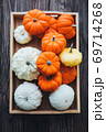 Autumn composition of miniature decorative pumpkins on a wooden table. 69714268