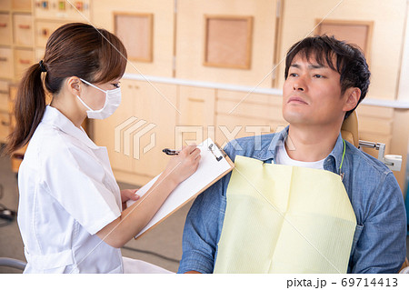 歯磨き指導をする歯科衛生士と男性患者の写真素材