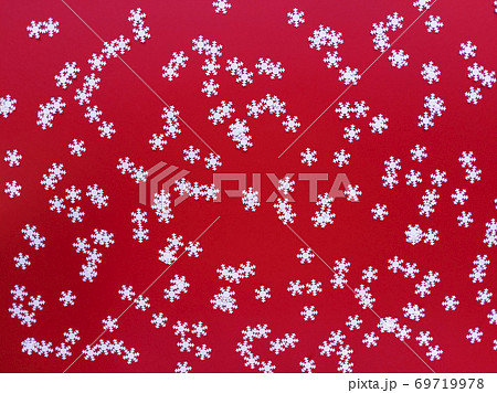 Scattered white snowflakes on red background. Simple festive flat lay. Stock photo. Scattered white snowflakes on red background. Simple festive flat lay. Stock photo. 69719978