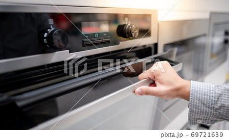 Male hand opening oven door 69721639