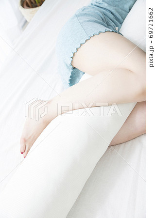 抱き枕を抱いて眠る女性 69721662