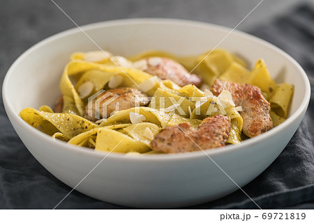 Pasta tagliatelle with chicken, pest and almonds in white bowl Pasta tagliatelle with chicken, pest and almonds in white bowl 69721819