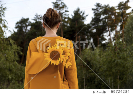 Girl with sunflowers in the autumn nature enjoys mindfulness 69724284
