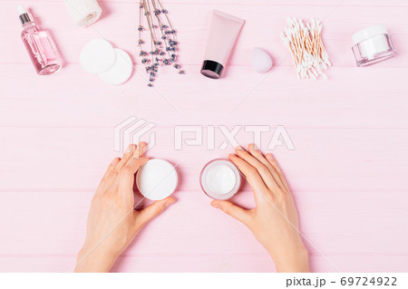 Top view female hands holding open jar of cosmetic cream 69724922
