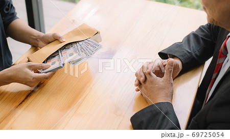 Businessman giving money while making deal to agreement a real estate contract and financial corporate.Bribery and corruption concept 69725054
