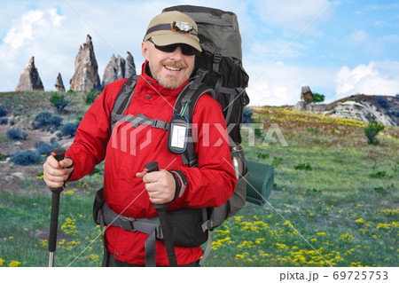 Happy tourist with backpack is traveling in the highlands. Volcanic rocks in Cappadocia valley Happy tourist with backpack is traveling in the highlands. Volcanic rocks in Cappadocia valley 69725753