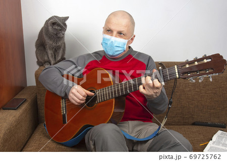 man in a medical mask at home in quarantine because of an epidemic of coronavirus man in a medical mask at home in quarantine because of an epidemic of coronavirus 69725762