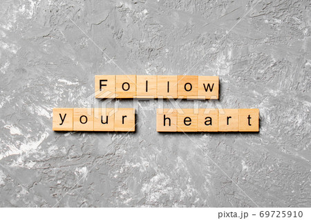 Follow your heart word written on wood block. Follow your heart text on cement table for your desing, Top view concept Follow your heart word written on wood block. Follow your heart text on cement table for your desing, Top view concept 69725910