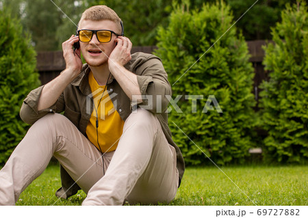 bearded guy listening to music in headphones and joyfully singing closed eyes bearded guy listening to music in headphones and joyfully singing closed eyes 69727882