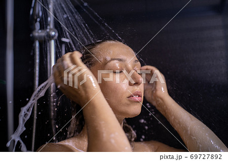 Calm and balanced young woman hair taking shower with shampoo foam 69727892