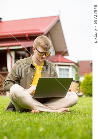 Cheerful young male student training webinar on laptop computer outdoors Cheerful young male student training webinar on laptop computer outdoors 69727948