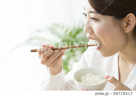 ご飯を食べる女性 69728317