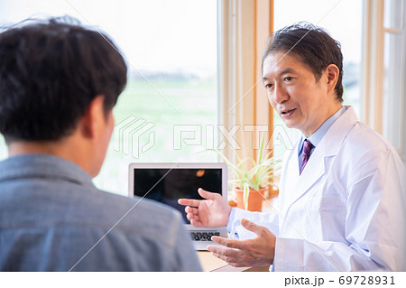 男性を診察する医師 男性を診察する医師 69728931