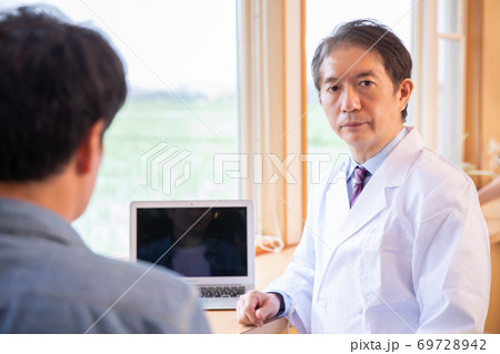 男性を診察する医師 男性を診察する医師 69728942