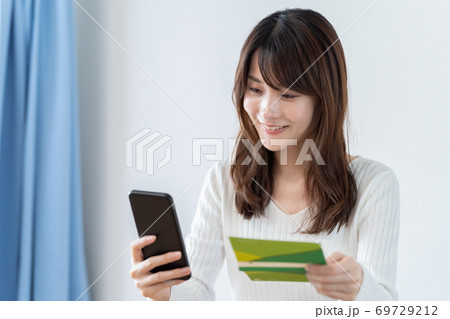 スマートフォンで通帳残高を確認する女性 スマートフォンで通帳残高を確認する女性 69729212
