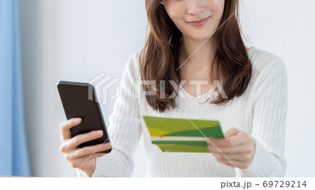 スマートフォンで通帳残高を確認する女性 69729214