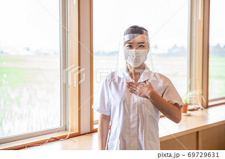 フェイスシールドをする看護師 69729631