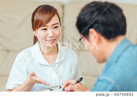 問診する看護師と男性患者 69730692