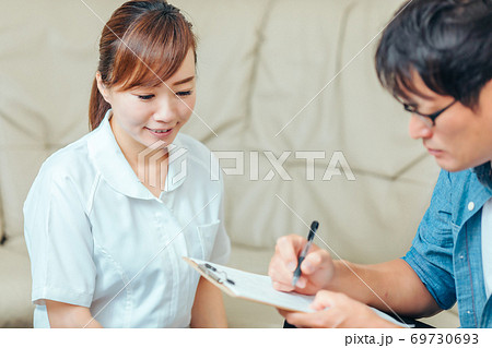 問診する看護師と男性患者 69730693